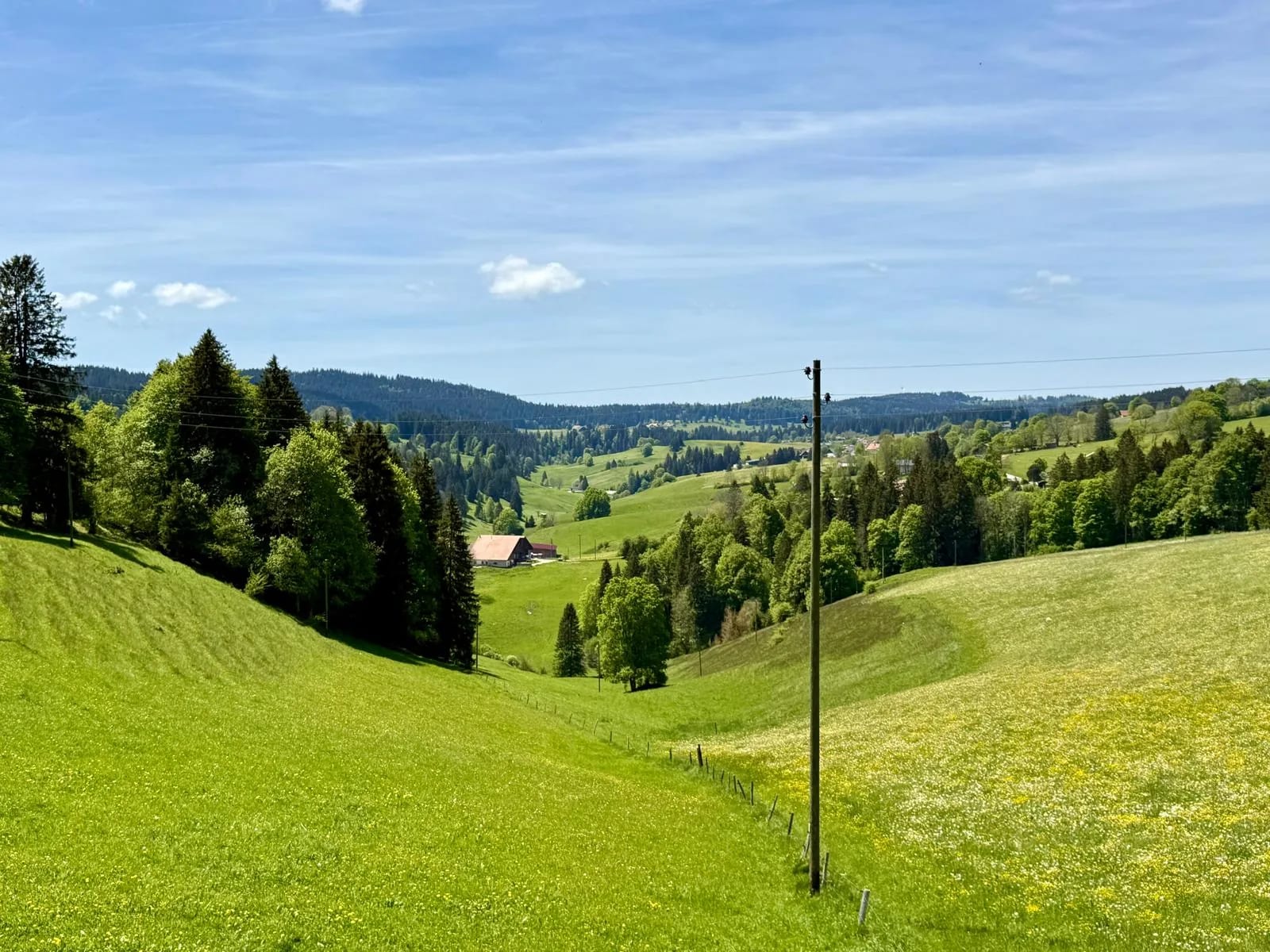 Vallée du Val-de-Travers au printemps, ferme jurassienne au creux des pâturages verdoyants